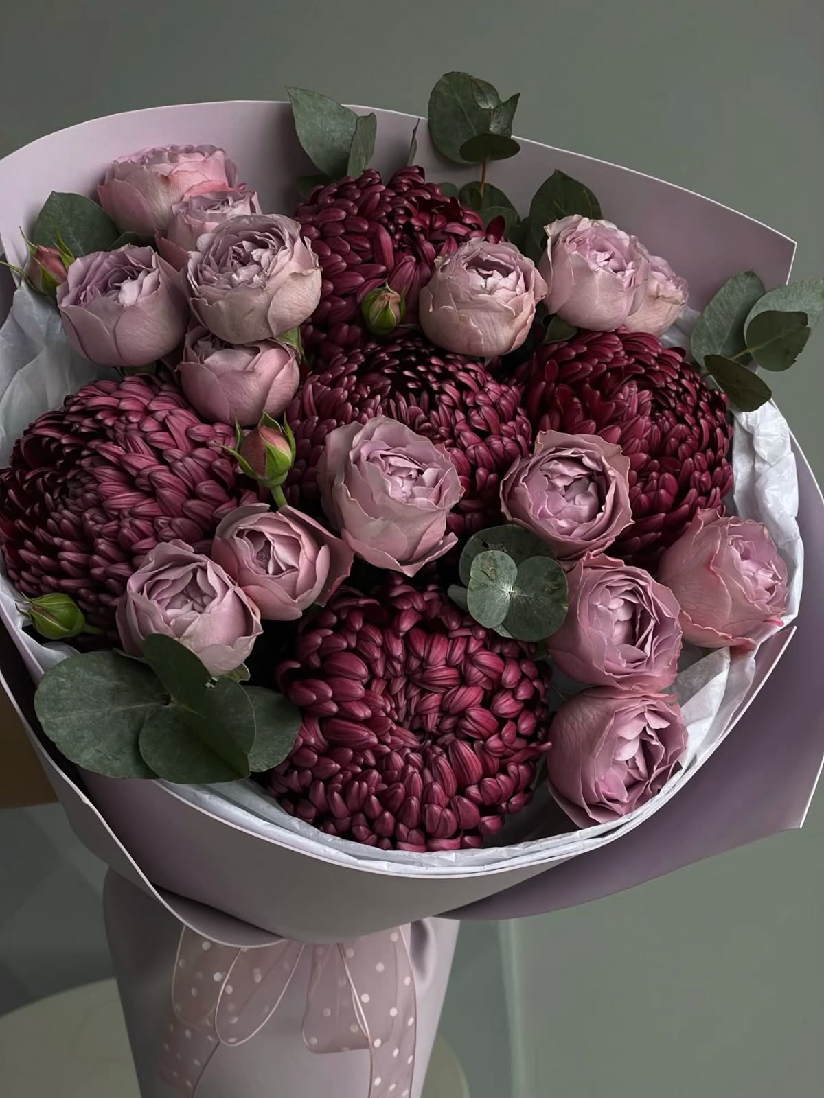 Ein Blumenstrauß aus violetten Buschrosen und Chrysanthemen „Bigudi“